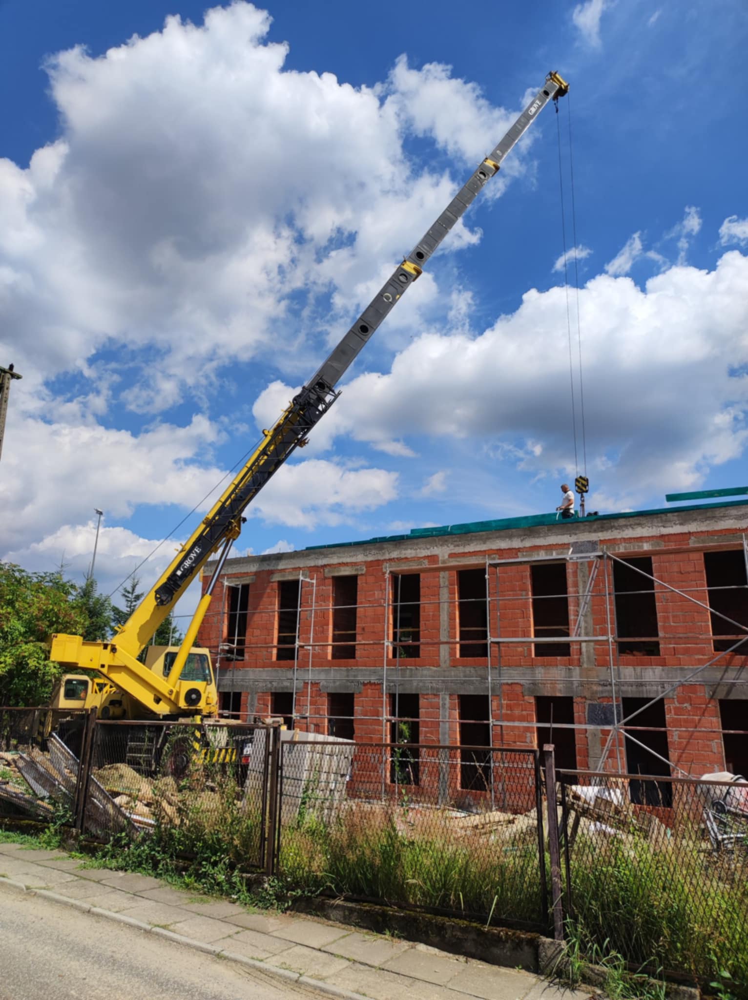 Dźwig na placu budowy z budynkiem w tle