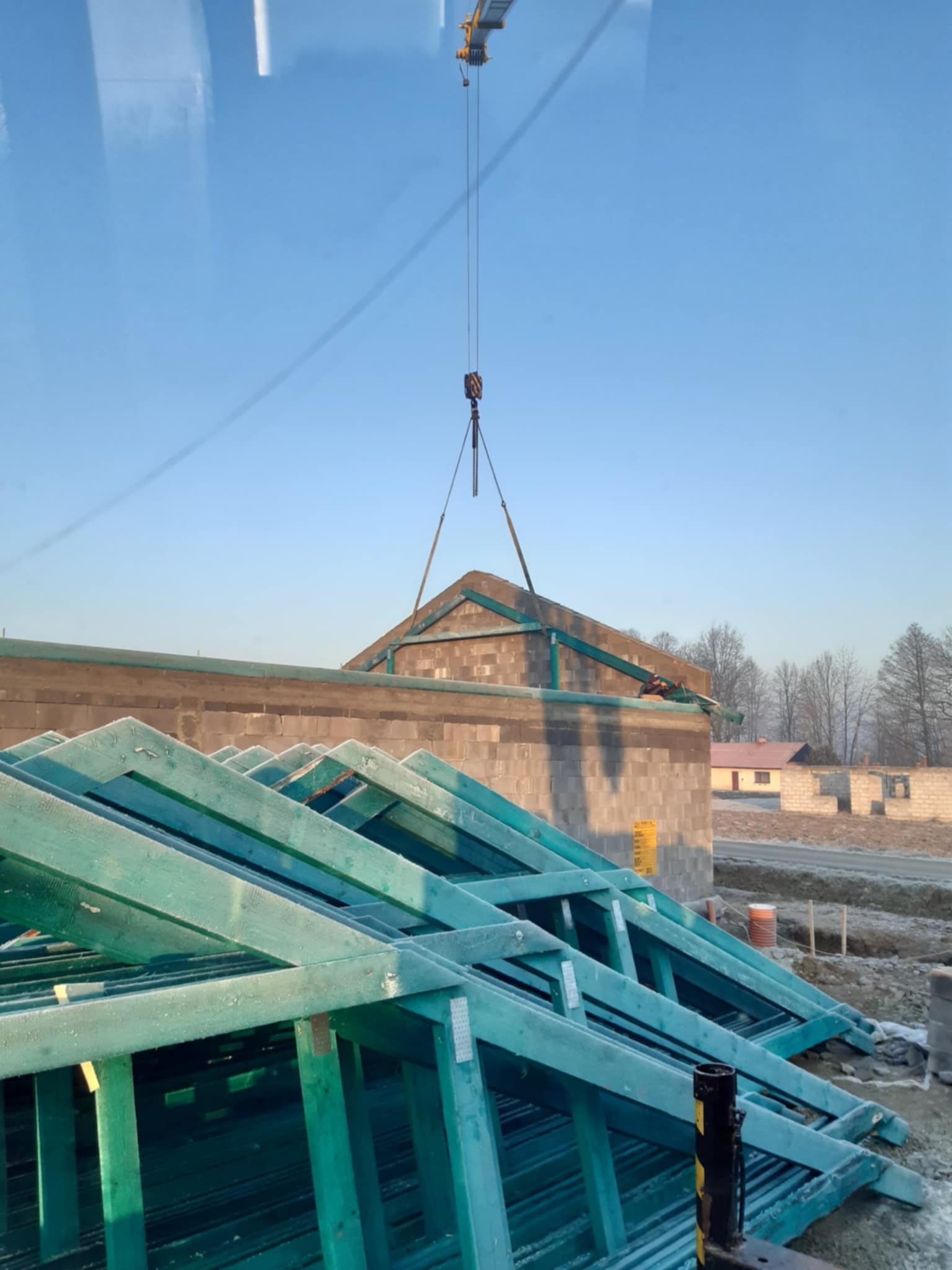 Dźwig montujący konstrukcję dachu zimą