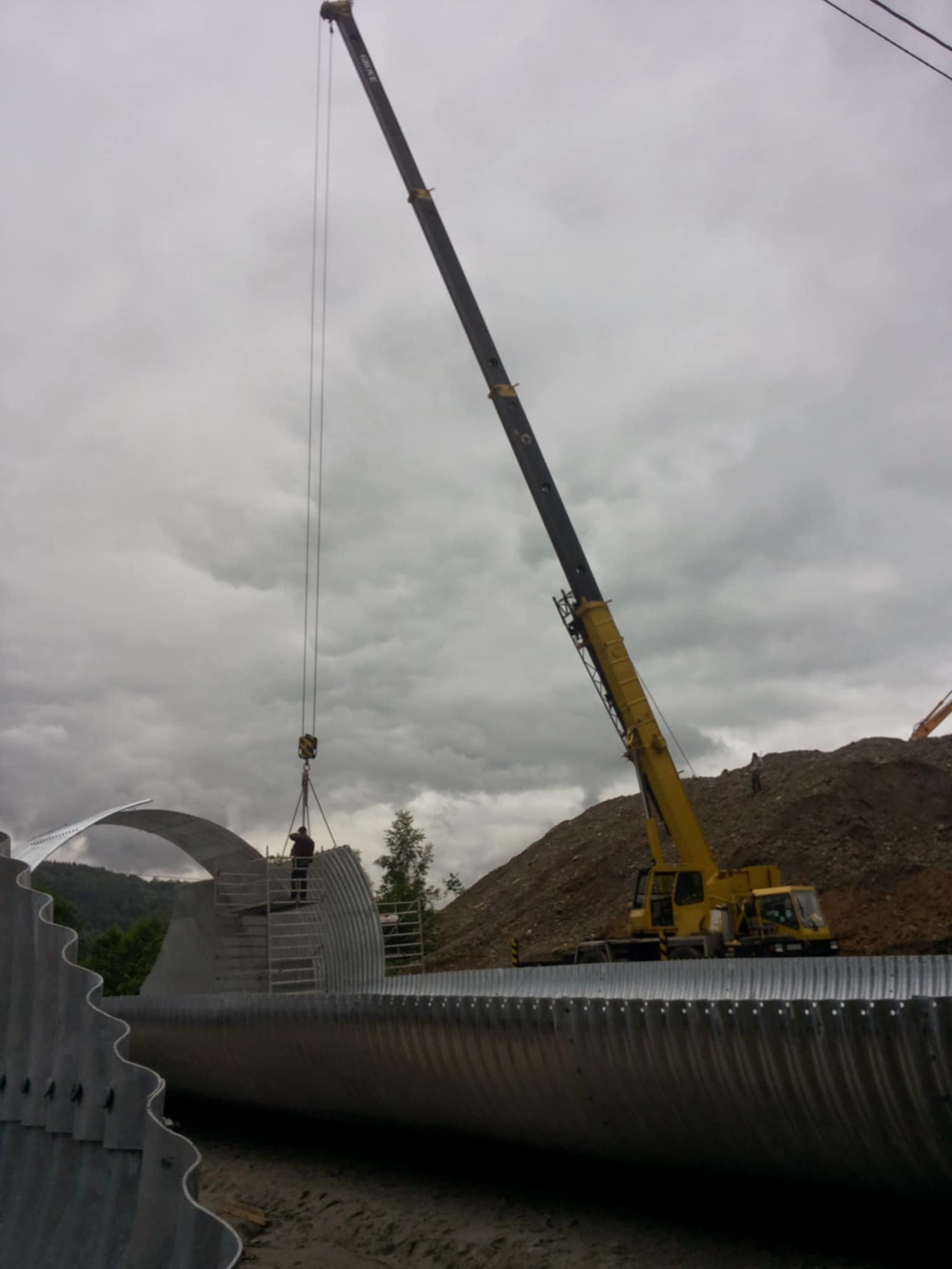 Duży dźwig na placu budowy przy montażu rury